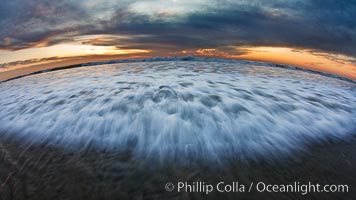 Sunset and incoming surf, gorgeous colors in the sky and on the ocean at dusk, the incoming waves are blurred in this long exposure.