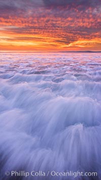 Sunset and incoming surf, gorgeous colors in the sky and on the ocean at dusk, the incoming waves are blurred in this long exposure, Carlsbad, California