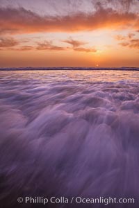 Sunset and incoming surf, gorgeous colors in the sky and on the ocean at dusk, the incoming waves are blurred in this long exposure, Carlsbad, California