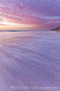 Sunset and incoming surf, gorgeous colors in the sky and on the ocean at dusk, the incoming waves are blurred in this long exposure, Carlsbad, California