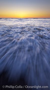 Sunset and incoming surf, gorgeous colors in the sky and on the ocean at dusk, the incoming waves are blurred in this long exposure, Carlsbad, California