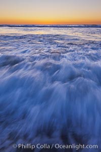 Sunset and incoming surf, gorgeous colors in the sky and on the ocean at dusk, the incoming waves are blurred in this long exposure, Carlsbad, California