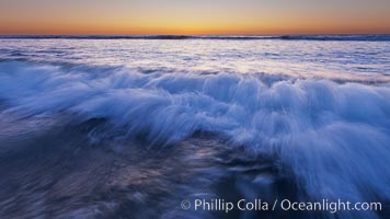 Sunset and incoming surf, gorgeous colors in the sky and on the ocean at dusk, the incoming waves are blurred in this long exposure, Carlsbad, California