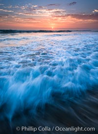 Sunset and incoming surf, gorgeous colors in the sky and on the ocean at dusk, the incoming waves are blurred in this long exposure, Carlsbad, California
