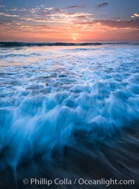 Sunset and incoming surf, gorgeous colors in the sky and on the ocean at dusk, the incoming waves are blurred in this long exposure.