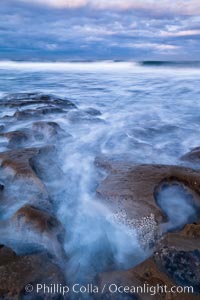 Waves wash over sandstone reef, clouds and sky, La Jolla, California