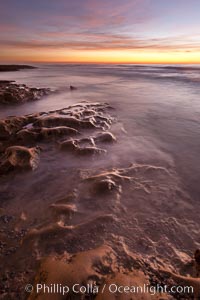 Waves wash over sandstone reef, clouds and sky, La Jolla, California