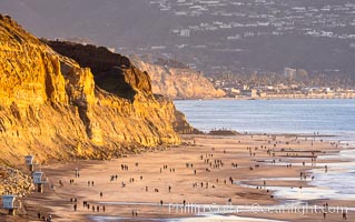 Torrey Pines State Beach on the extreme low King Tide, people walking on the beach, sunset light and La Jolla in the distance, Torrey Pines State Reserve, San Diego, California