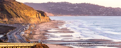 Torrey Pines State Beach on the extreme low King Tide, people walking on the beach, sunset light and La Jolla in the distance, Torrey Pines State Reserve, San Diego, California