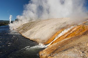 Thermophilac heat-loving bacteria color the runoff canals from Excelsior Geyser as it empties into the Firehole River, Midway Geyser Basin, Yellowstone National Park, Wyoming