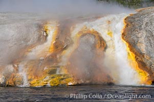 Thermophilac heat-loving bacteria color the runoff canals from Excelsior Geyser as it empties into the Firehole River, Midway Geyser Basin, Yellowstone National Park, Wyoming