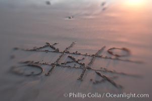 Tic-tac-toe in the sand on the beach.