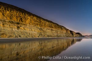 Torrey Pines Cliffs lit at night by a full moon, low tide reflections, Torrey Pines State Reserve, San Diego, California