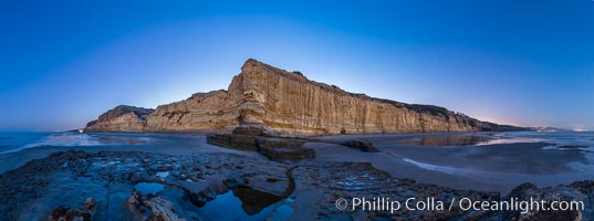 Torrey Pines Cliffs lit at night by a full moon, low tide reflections.