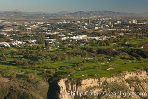 Torrey Pines golf course, situated atop the magnificent 300 foot tall seacliffs, offers majestic views of the Pacific Ocean south to La Jolla.  Scattered around the course are found Torrey pine trees, one of the rare species of pines in the world.  Some of La Jolla's biotechnology companies are seen on the far side of the golf course, along North Torrey Pines Road, San Diego, California