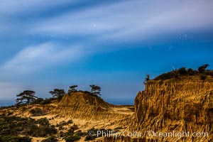 Torrey Pines State Reserve at Night, stars and clouds fill the night sky, the Pacific Ocean in the distance, San Diego, California