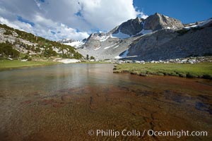 Townsley Lake, a beautiful alpine lake sitting below blue sky, clouds and Fletcher Peak (right), lies amid the Cathedral Range of glacier-sculpted granite peaks in Yosemite's high country, near Vogelsang High Sierra Camp, Yosemite National Park, California