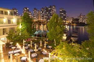 Vancouver and harbor at night, viewed from Granville Island Hotel with restaurant courtyard in the foreground