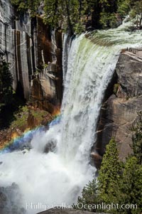 Vernal Falls at peak flow in late spring, hikers visible at precipice, viewed from John Muir Trail, Yosemite National Park, California