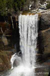 Vernal Falls at peak flow in late spring. Hikers are seen at the precipice to Vernal Falls, having hiked up the Mist Trail to get there, Yosemite National Park, California