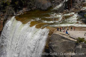 Vernal Falls at peak flow in late spring. Hikers are seen at the precipice to Vernal Falls, having hiked up the Mist Trail to get there, Yosemite National Park, California