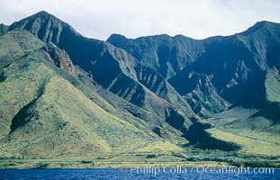 West Maui mountains rise above the coast of Maui, with clouds flanking the ancient eroded remnants of a volcano