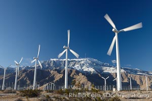 Wind turbines, rise above the flat floor of the San Gorgonio Pass near Palm Springs, with snow covered Mount San Jacinto in the background, provide electricity to Palm Springs and the Coachella Valley