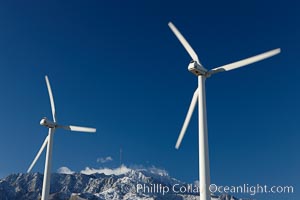 Wind turbines, rise above the flat floor of the San Gorgonio Pass near Palm Springs, with snow covered Mount San Jacinto in the background, provide electricity to Palm Springs and the Coachella Valley