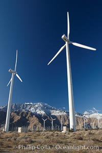 Wind turbines, rise above the flat floor of the San Gorgonio Pass near Palm Springs, with snow covered Mount San Jacinto in the background, provide electricity to Palm Springs and the Coachella Valley