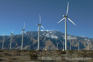 Wind turbines, rise above the flat floor of the San Gorgonio Pass near Palm Springs, with snow covered Mount San Jacinto in the background, provide electricity to Palm Springs and the Coachella Valley