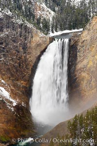 Snow covers the rocks and cliffs around Lower Yellowstone Falls in winter. At 308 feet, the Lower Falls of the Yellowstone River is the tallest fall in the park. This view is from Lookout Point on the North side of the Grand Canyon of the Yellowstone, Yellowstone National Park, Wyoming