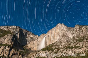 Yosemite Falls and star trails, at night, viewed from Cook's Meadow, illuminated by the light of the full moon.