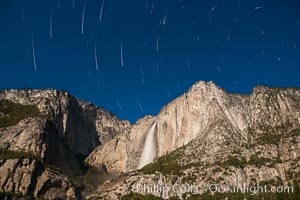 Yosemite Falls and star trails, at night, viewed from Cook's Meadow, illuminated by the light of the full moon.
