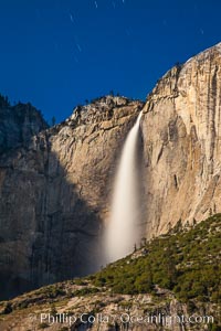 Yosemite Falls and star trails, at night, viewed from Cook's Meadow, illuminated by the light of the full moon.