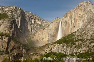 Yosemite Falls by moonlight, viewed from Cooks Meadow. Star trails appear in the night sky. Yosemite Valley, Yosemite National Park, California