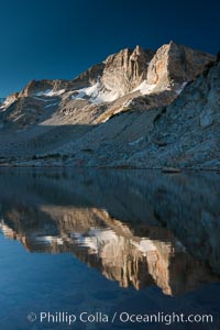Cathedral Range peaks reflected in the still waters of Townsley Lake at sunrise, high country near Vogelsang High Sierra Camp, Yosemite National Park.