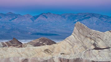 Zabriskie Point, sunrise.  Manly Beacon rises in the center of an eroded, curiously banded area of sedimentary rock, with the Panamint Mountains visible in the distance.