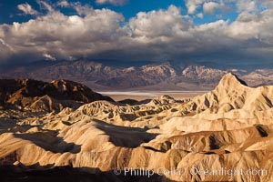 Sunrise at Zabriskie Point, Manly Beacon is lit by the morning sun while clouds from a clearing storm pass by, Death Valley National Park, California