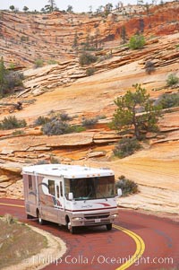 A motorhome recreational vehicle RV travels through the red rocks of Zion National Park.