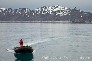 Zodiac inflatable skiff boat, with mountains of South Georgia Island, on the Bay of Isles, Salisbury Plain