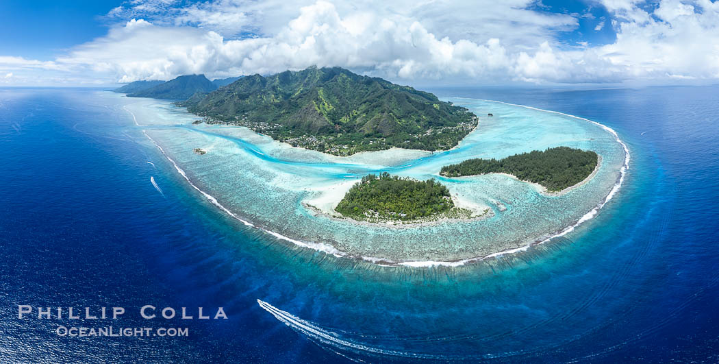 Barrier Reef around Moorea Island, French Polynesia. Motu Tiahura (left) and Motu Fareone (right) are the small islands in the foreground. The outer reef slope is seen adjacent to deep blue oceanic water with white waves breaking against the reef edge. Next, a wide shallow reef flat occurs dotted with coral bommies. Inside of that, a shallow protected lagoon is formed against the island.  Tall, rugged, eroded mountains are seen hinting at the age of the ancient volcano that originally formed the island and that is now sinking back down, leaving the encircling reef behind. France, natural history stock photograph, photo id 40614