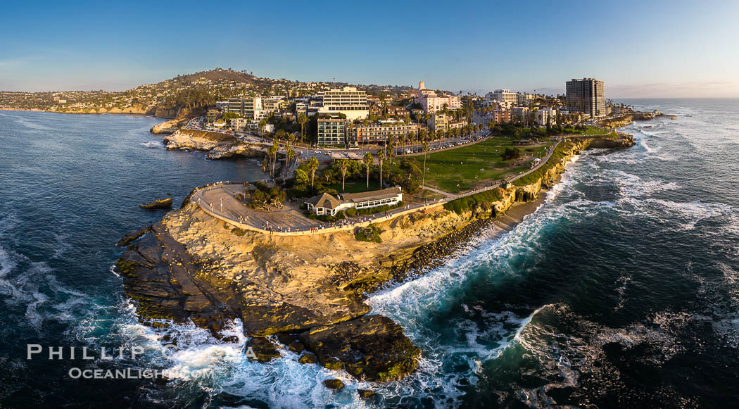 Aerial Panoramic Photo of Point La Jolla at sunset, La Jolla and Mount Soledad. People enjoying the sunset on the sea wall looking at sea lions on the rocks