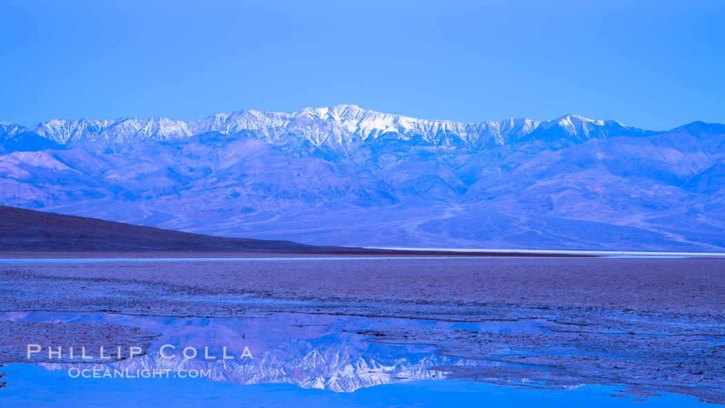 Sunrise lights Telescope Peak as it rises over the salt flats of Badwater, Death Valley.  At 11,049 feet, Telescope Peak is the highest peak in the Panamint Range as well as the highest point in Death Valley National Park.  At 282 feet below sea level, Badwater is the lowest point in North America. California, USA, natural history stock photograph, photo id 20549