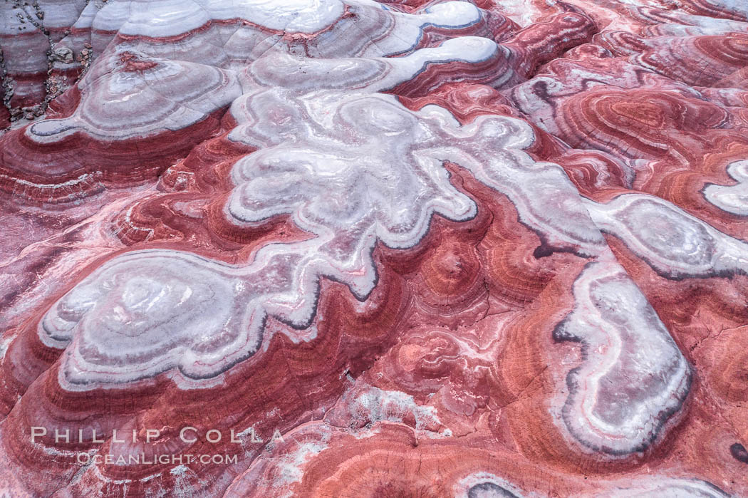 Fantastic colorful sedimentary patterns of Bentonite layers, seen as striations exposed in the Utah Badlands. The Bentonite Hills are composed of the Brushy Basin shale member of the Morrison Formation formed during Jurassic times when mud, silt, fine sand, and volcanic ash were deposited in swamps and lakes into layers, now revealed through erosion. Aerial photograph. USA, natural history stock photograph, photo id 37947