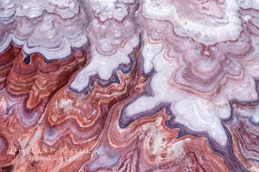 Fantastic colorful sedimentary patterns of Bentonite layers, seen as striations exposed in the Utah Badlands. The Bentonite Hills are composed of the Brushy Basin shale member of the Morrison Formation formed during Jurassic times when mud, silt, fine sand, and volcanic ash were deposited in swamps and lakes into layers, now revealed through erosion. Aerial photograph. USA, natural history stock photograph, photo id 38056