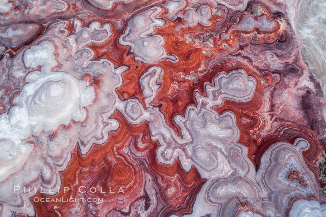 Fantastic colorful sedimentary patterns of Bentonite layers, seen as striations exposed in the Utah Badlands. The Bentonite Hills are composed of the Brushy Basin shale member of the Morrison Formation formed during Jurassic times when mud, silt, fine sand, and volcanic ash were deposited in swamps and lakes into layers, now revealed through erosion. Aerial photograph. USA, natural history stock photograph, photo id 38047