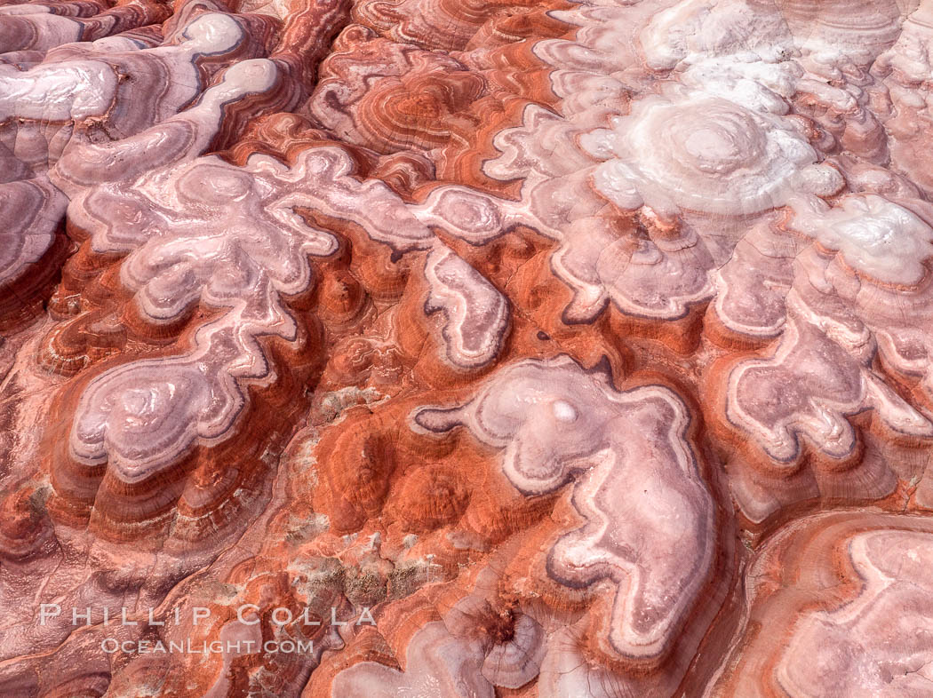 Fantastic colorful sedimentary patterns of Bentonite layers, seen as striations exposed in the Utah Badlands. The Bentonite Hills are composed of the Brushy Basin shale member of the Morrison Formation formed during Jurassic times when mud, silt, fine sand, and volcanic ash were deposited in swamps and lakes into layers, now revealed through erosion. Aerial photograph. USA, natural history stock photograph, photo id 38067