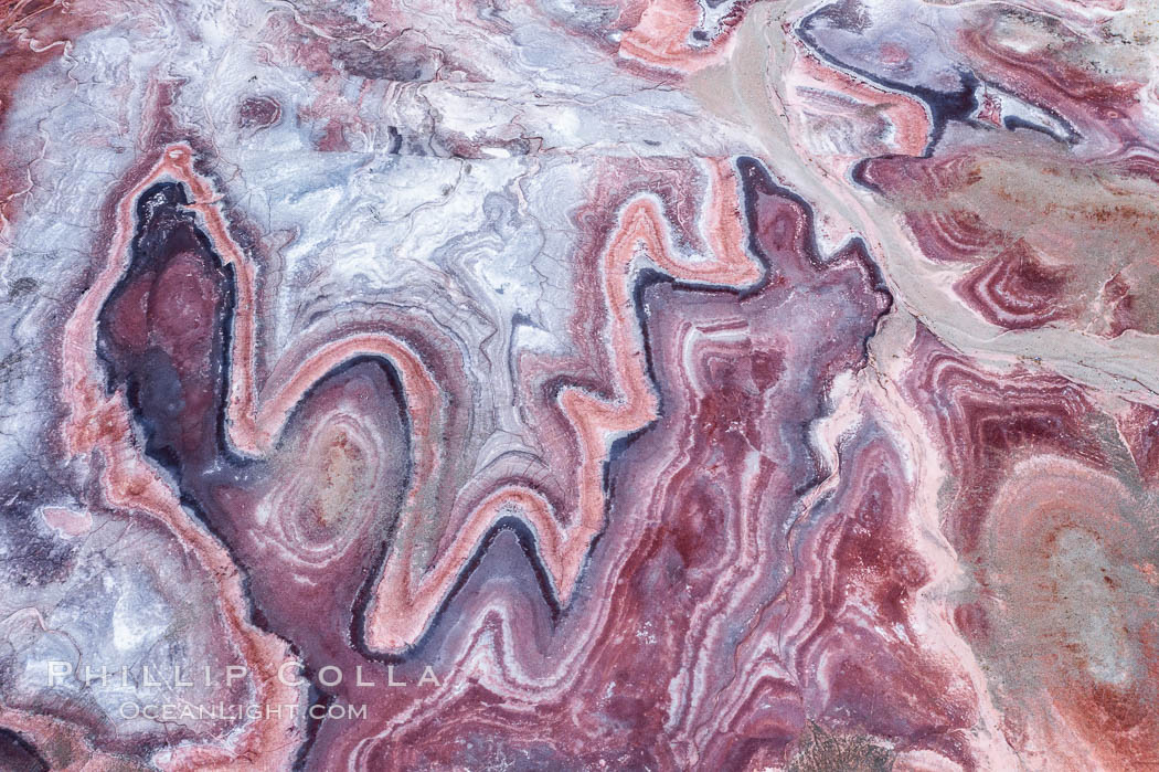 Fantastic colorful sedimentary patterns of Bentonite layers, seen as striations exposed in the Utah Badlands. The Bentonite Hills are composed of the Brushy Basin shale member of the Morrison Formation formed during Jurassic times when mud, silt, fine sand, and volcanic ash were deposited in swamps and lakes into layers, now revealed through erosion. Aerial photograph. USA, natural history stock photograph, photo id 38053