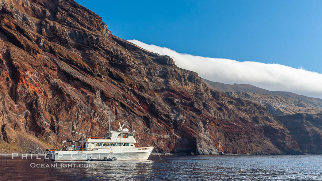 Guadalupe Islands mountainous terrain and sea cliffs tower above the dive boat Horizon while at anchor in Spanish Cove, near the north end of Guadalupe Island (Isla Guadalupe). Baja California, Mexico, natural history stock photograph, photo id 09741