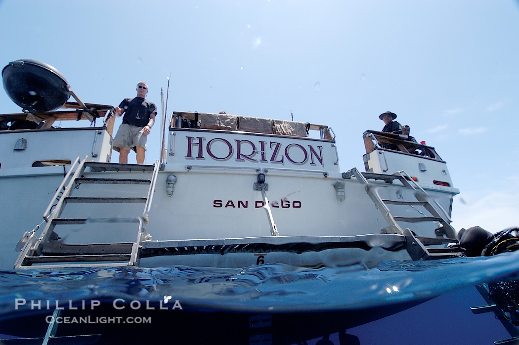 Crew of the dive boat Horizon wait at the stern to help divers out of the water., natural history stock photograph, photo id 09723